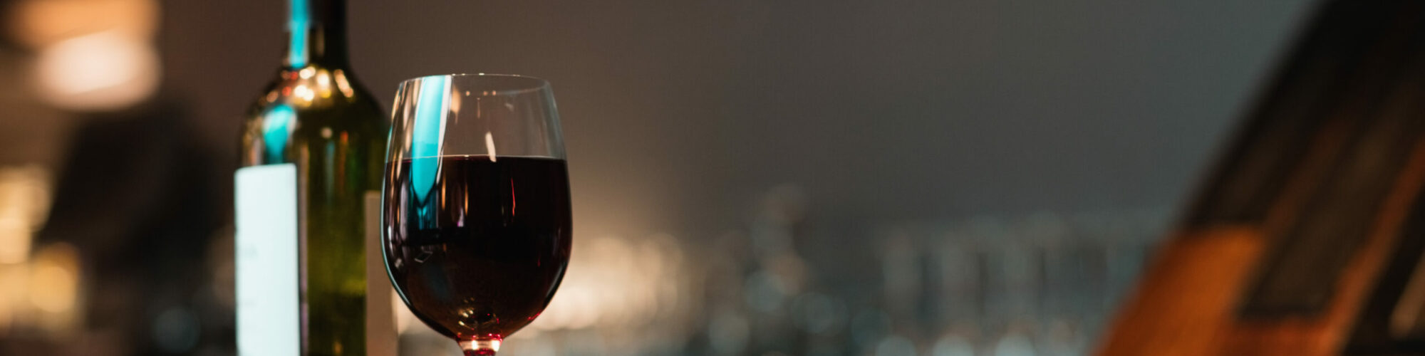 Climatisation de cave à vin - KeepCool Hainaut Glass of red wine and bottle on bar counter at bar